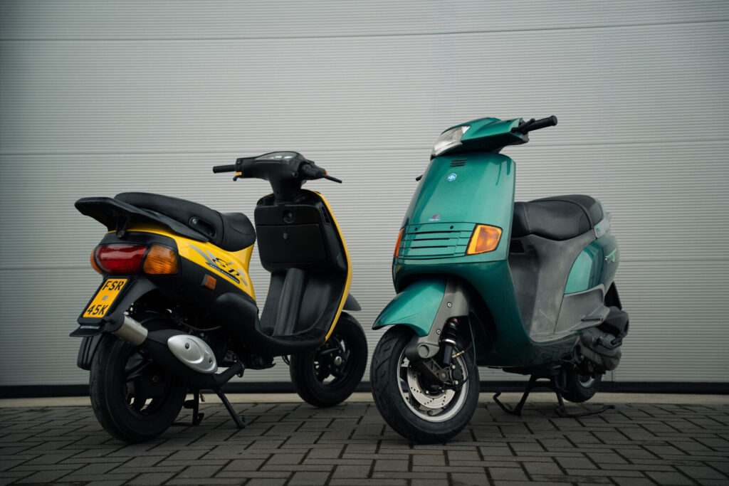 Gele Piaggio Zip naast een groene klassieker in Hoogeveen