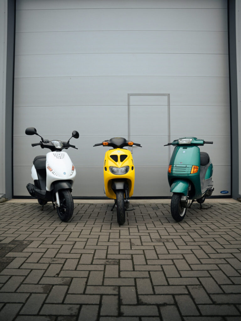 Drie klassieke Piaggio scooters voor de showroom in Hoogeveen